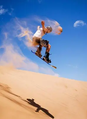 a man flying through the air on a snowboard at Merzouga Desert Activities & Events in Merzouga