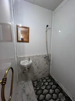 a white bathroom with a sink and a shower at Tikida house in Ouzoud