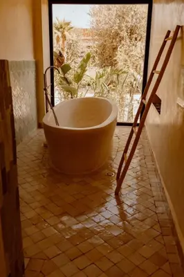 a large bath tub sitting in a room with a window at Villa de luxe in Marrakech