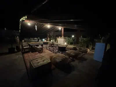 a group of chairs and tables under a tent at night at Lodge bio berber nomad in Nkob