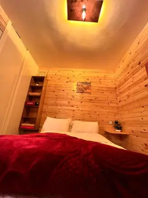 a bedroom with a bed in a wooden wall at Tikida house in Ouzoud