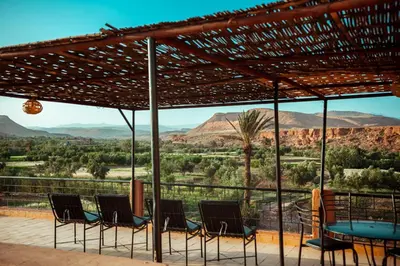 a patio with chairs and a table with a view at Riad Zaytoune in Ouarzazate