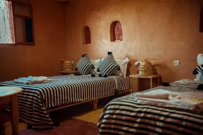 a bedroom with two beds with striped sheets at Riad Zaytoune in Ouarzazate