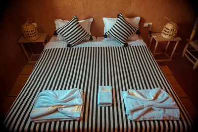 a bed with two towels on top of it at Riad Zaytoune in Ouarzazate