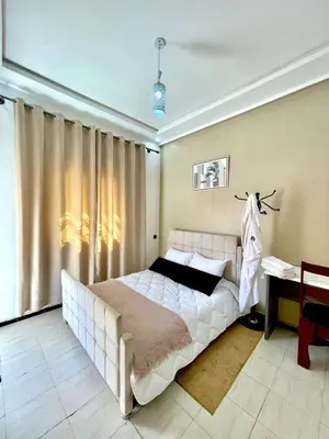a bedroom with a large white bed and a desk at hotel darna with air conditioning in Er Rachidia