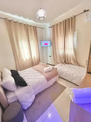 a bedroom with a large bed and a tv at hotel darna with air conditioning in Er Rachidia