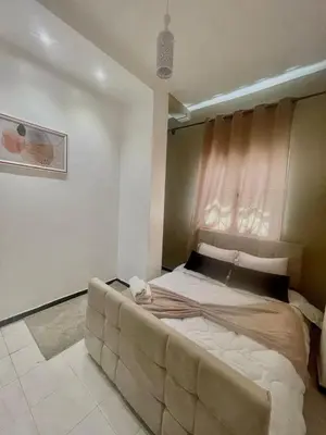 a bedroom with a large bed with a couch at hotel darna with air conditioning in Er Rachidia