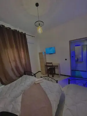 a bedroom with a bed and a room with a window at hotel darna with air conditioning in Er Rachidia