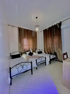 two beds in a room with purple lighting at hotel darna with air conditioning in Er Rachidia