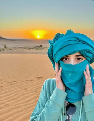 a woman wearing a hijab on the desert at Merzouga Dunes Luxury Glamping Camp in Merzouga