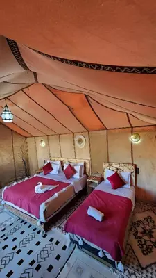 a bedroom with two beds in a tent at Merzouga Dunes Luxury Glamping Camp in Merzouga