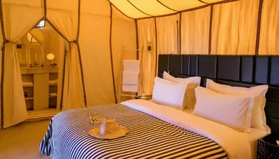 a bed in a tent with a stuffed animal on it at Merzouga Dunes Luxury Glamping Camp in Merzouga