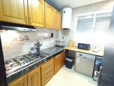 a kitchen with a sink and a stove top oven at Jolie appartement à Ifrane calme et spacieux in Ifrane