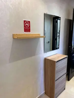 a mirror and a wooden shelf on a wall at Jolie appartement à Ifrane calme et spacieux in Ifrane