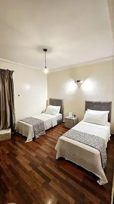two beds in a room with wooden floors at Maison Chafik in Fès