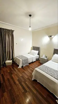 two beds in a room with wooden floors at Maison Chafik in Fès