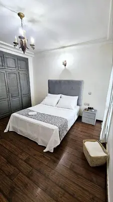 a bedroom with a large bed and a wooden floor at Maison Chafik in Fès