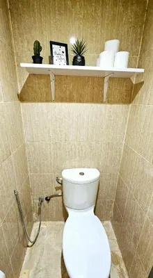 a bathroom with a toilet and shelves on the wall at Maison Chafik in Fès