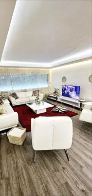 a living room with white furniture and a flat screen tv at Maison Chafik in Fès