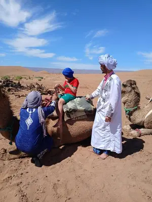a group of people on a camel in the desert at The dune camp in Mhamid