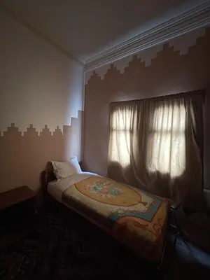 a small bedroom with a bed with a window at Taghadoute Hotel in Tazenakht