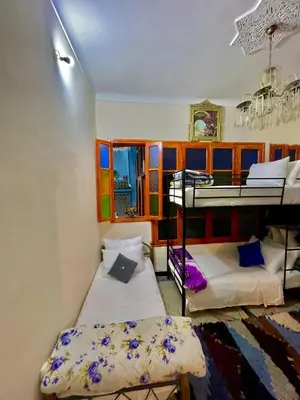 a bedroom with two bunk beds and a window at Blue Star Hostel in Fès