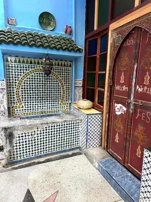 a blue building with a bench next to a door at Blue Star Hostel in Fès