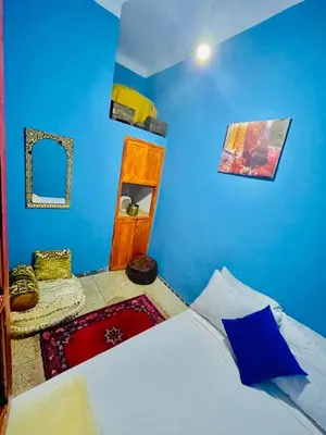 a blue bedroom with a bed and a mirror at Blue Star Hostel in Fès
