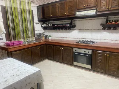 a kitchen with wooden cabinets and a stove at Meknes in Meknès