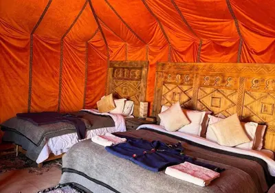 a bedroom with two beds in an orange tent at Erg Chegaga Charming Camp in El Gouera