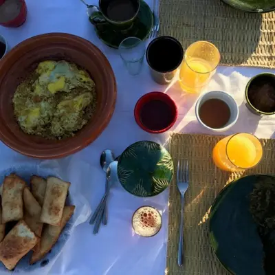 a table with a bowl of food and a plate of bread at Erg Chegaga Charming Camp in El Gouera
