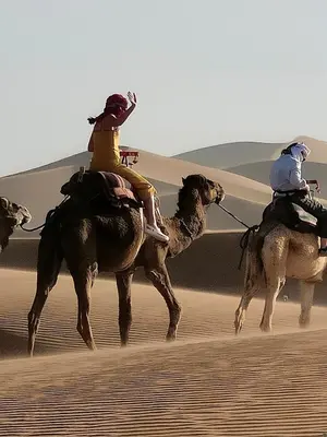 two people riding on horses in the desert at Erg Chegaga Charming Camp in El Gouera