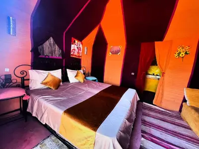 a bedroom with a bed in a room with colorful walls at Morocco wonderland in Merzouga