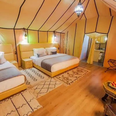 a bedroom with two beds in a tent at Cleopatra luxury camp in Merzouga