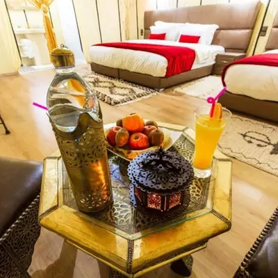 a living room with a table with a drink and food on it at Cleopatra luxury camp in Merzouga