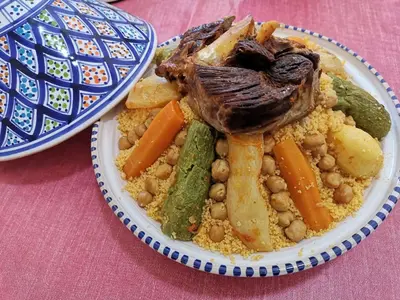 a plate of food with meat and vegetables on a table at Cleopatra luxury camp in Merzouga