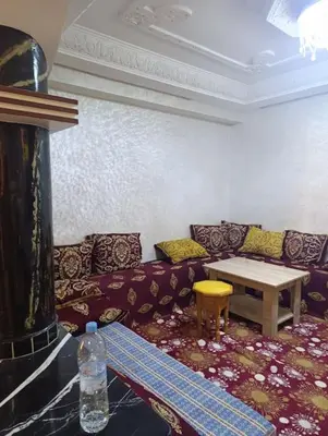 a living room with a couch and a table at Appartement tradimoderne in Mrhila