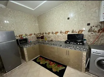 a kitchen with a counter with a refrigerator and a washer at بدون اسم in Fès