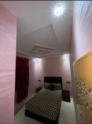 a bedroom with a bed and a light on the ceiling at بدون اسم in Fès
