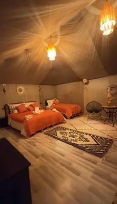a bedroom with a bed and a table in a tent at eclipse du desert in Merzouga