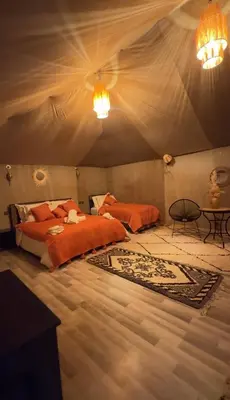 a bedroom with a bed and a table in a tent at eclipse du desert in Merzouga