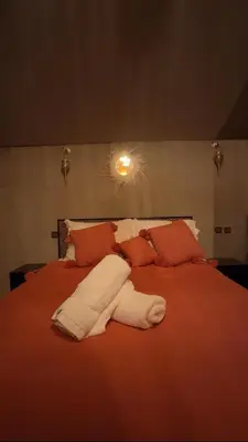 a large red bed with a white towel on it at eclipse du desert in Merzouga