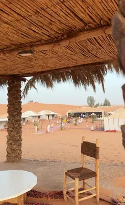 a wooden chair sitting in front of a beach at eclipse du desert in Merzouga