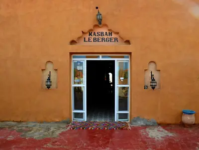 an orange building with a sign that readsacist league breaker at Kasbah Du Berger & Piscine in Merzouga