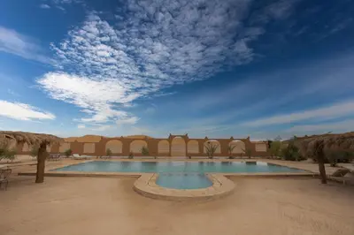 a swimming pool in the middle of a desert at Kasbah Du Berger & Piscine in Merzouga