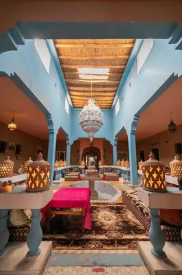 a large room with a pink table and a chandelier at Kasbah Du Berger & Piscine in Merzouga