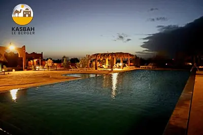 a pool of water in front of a building at Kasbah Du Berger & Piscine in Merzouga
