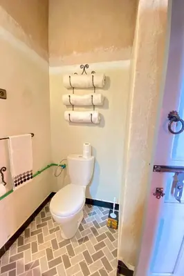 a bathroom with a toilet and towels at Nomadic Birdway in Imiter