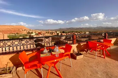 a table and chairs on a balcony with a view at Nomadic Birdway in Imiter
