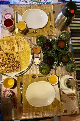 a table with plates of food on a table at Nomadic Birdway in Imiter